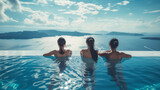 Three slender Asian women, positioned at the edge of an infinity pool, gaze out over the warm Mediterranean seas on a sunny day.