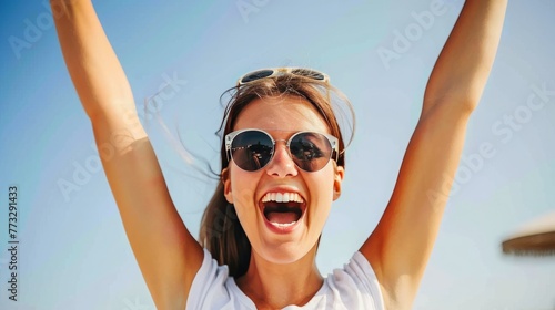young happy smiling attractive woman arms raised up and cheering, blue sky in the background, sunny day, 16:9
