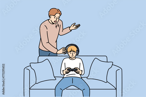 Father yells at naughty child who plays video games and refuses to do homework or comply with parents demands. Naughty guy resists upbringing, wanting to become cyber athlete or professional gamer