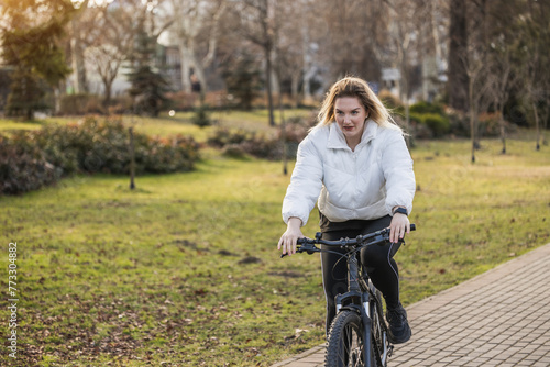 Woman Enjoys a Leisurely Bike Ride in the Park