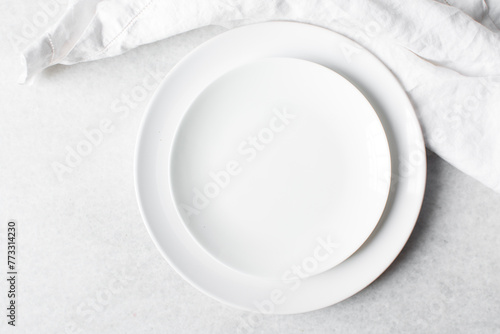 Top view of white ceramic plates on a marble table, white ceramic minimalist white plate