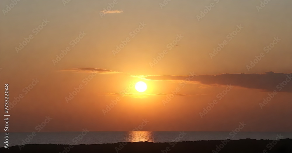 Fototapeta premium Stunning landscape of a golden sun setting over the horizon of a tranquil blue ocean