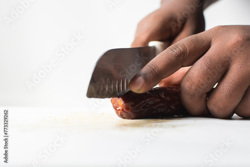Slicing chinese sausage on a white chopping board, lap cheong sausage being cut into thin slices on white background photo