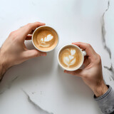 Two Hands Holding White Cups Filled with Coffee on a Clean Surface