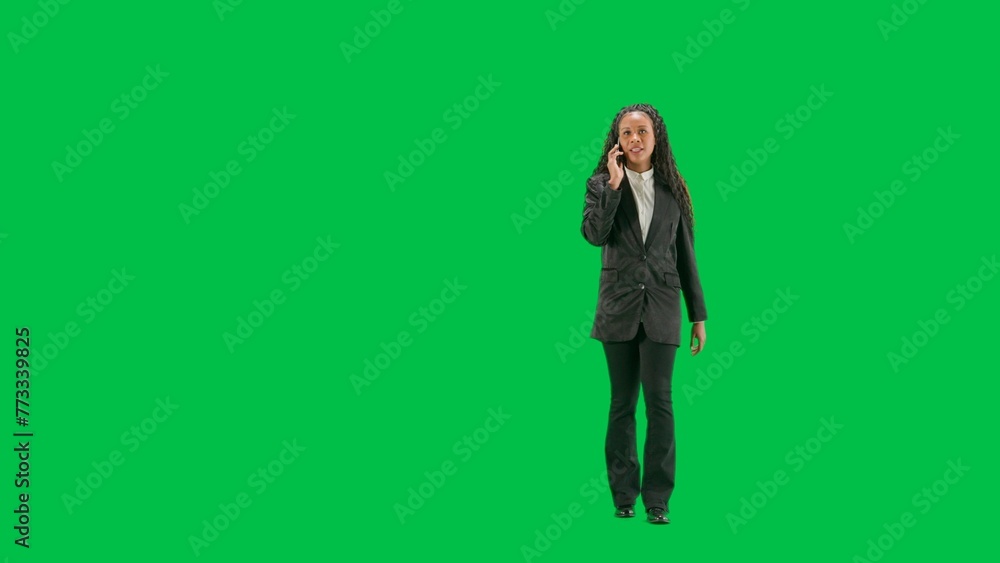 Young female reporter isolated on chroma key green screen background. Full shot african american woman tv news host walking and talking on smartphone. Young female reporter isolated on chroma key green screen background. Full shot african american woman tv news host walking and talking on smartphone.