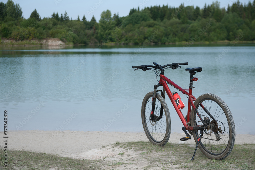 Fototapeta premium panoramic view of lake, bicycle in foreground