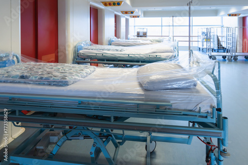 Clean hospital beds covered with film, ready for new patients. photo