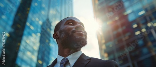 Happy wealthy rich successful black businessman standing in big city modern skyscrapers street on sunset thinking of successful vision, dreaming of new investment opportunities