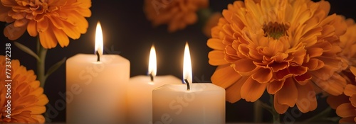 Velas encendidas con flores color naranja de cempasúchil  o flores de dia de muertos en un fondo obscuro. Imagen tamaño banner  photo