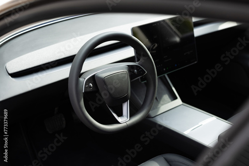 Steering wheel of electric vehicle, interior, cockpit, electric buttons. Autonomous car. Driverless car. Self-driving vehicle. Empty cockpit electric vehicle, Head Up Display and digital speedometer