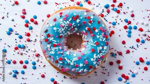 Blue iced doughnut with red and white star sprinkles on a clean white surface. Close-up shot with copy space.