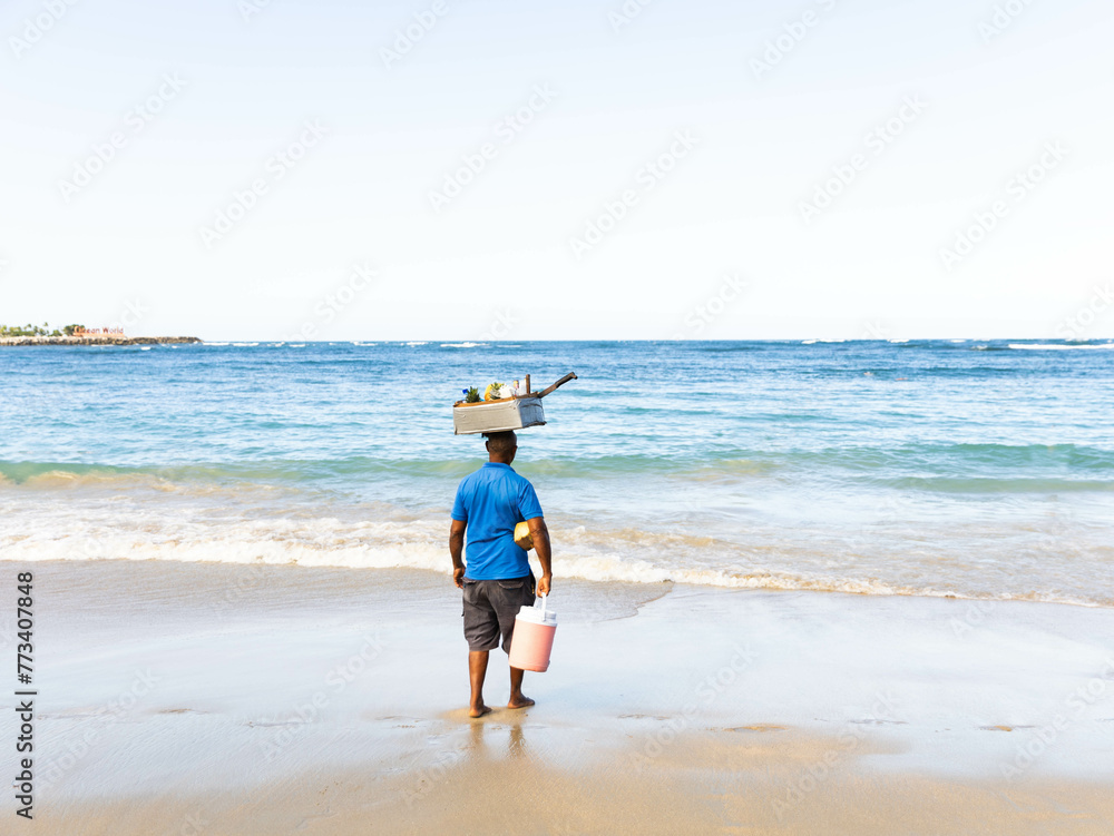 Domenican Republic beach with a man with a container with snacks and drinks