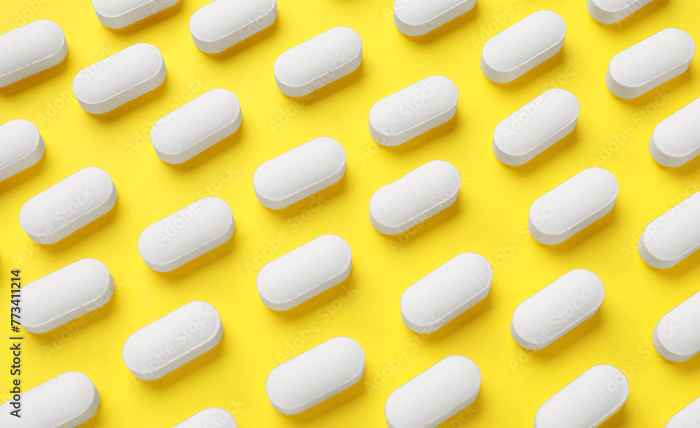 Vitamin pills on yellow background, flat lay Vitamin pills on yellow background, flat lay