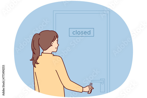 Indecisive woman pulls hand to door with inscription closed stands with back to screen. Girl is discouraged and does not know what to do after store is closed due to bankruptcy