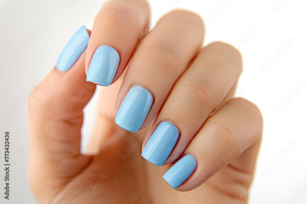 Beautiful woman's hand with light blue manicure on pastel background Beautiful woman's hand with light blue manicure on pastel background