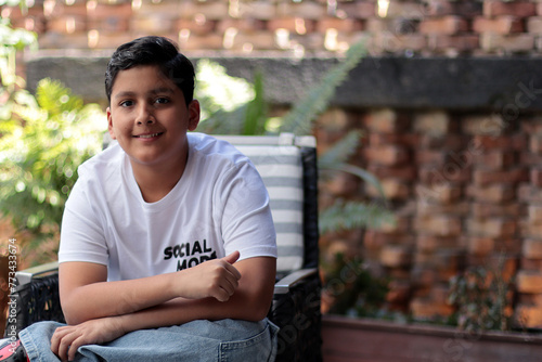 Niño latinoamericano feliz sentado en una silla 