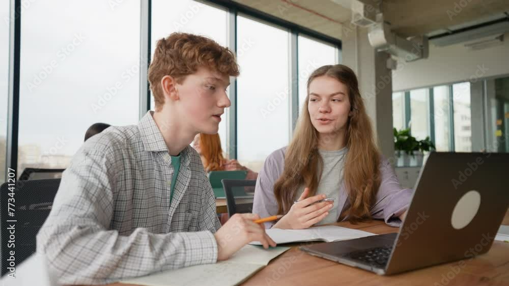 College students using laptop while sitting at table College students using laptop while sitting at table