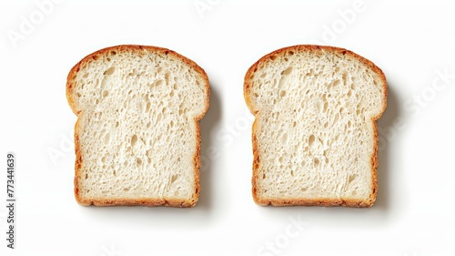 Two slices of white bread resting on a white surface