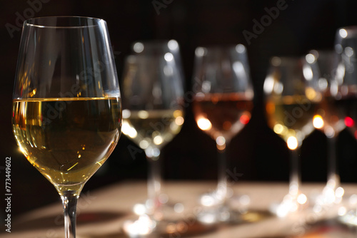 Tasty white wine in glass against blurred background, space for text