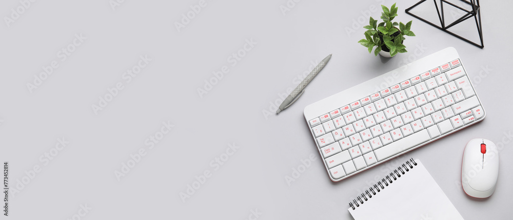 Fototapeta premium Wireless keyboard with computer mouse and office stationery on light background with space for text