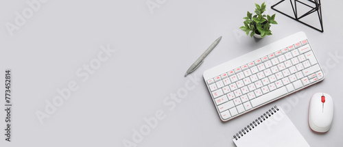 Wireless keyboard with computer mouse and office stationery on light background with space for text © Pixel-Shot