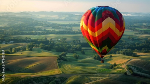 A colorful hot air balloon ride over patchwork fields and rolling hills.