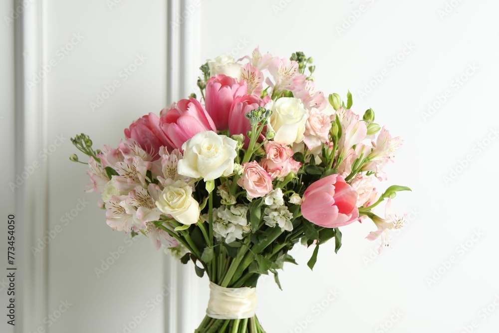 Beautiful bouquet of fresh flowers near white wall Beautiful bouquet of fresh flowers near white wall