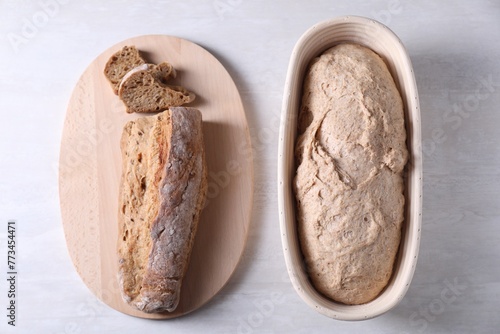 Vászonkép Fresh sourdough in proofing basket and bread on light table, top view