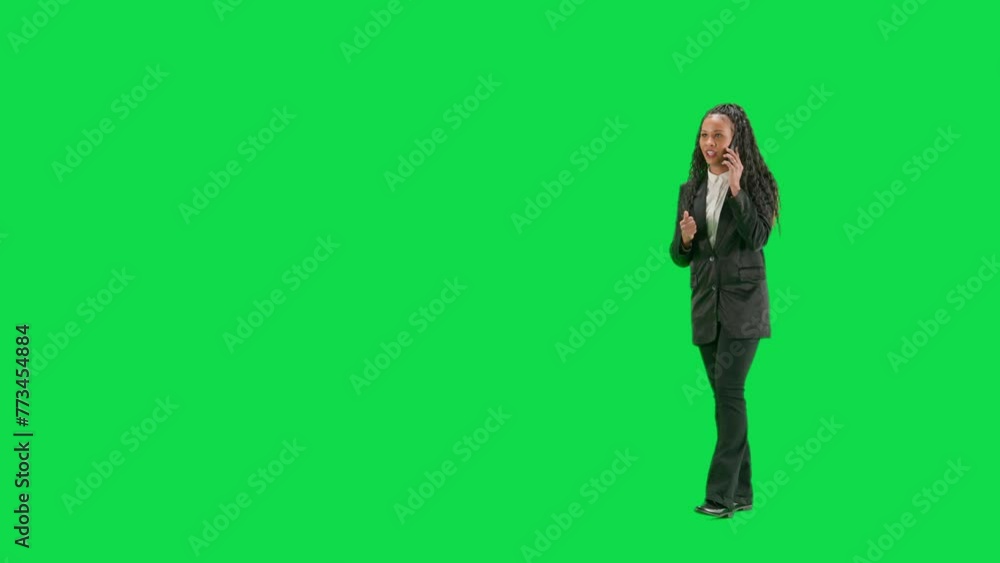 Young female reporter isolated on chroma key green screen background. Full shot african american woman tv news host walking and talking on smartphone. Half turn. Young female reporter isolated on chroma key green screen background. Full shot african american woman tv news host walking and talking on smartphone. Half turn.
