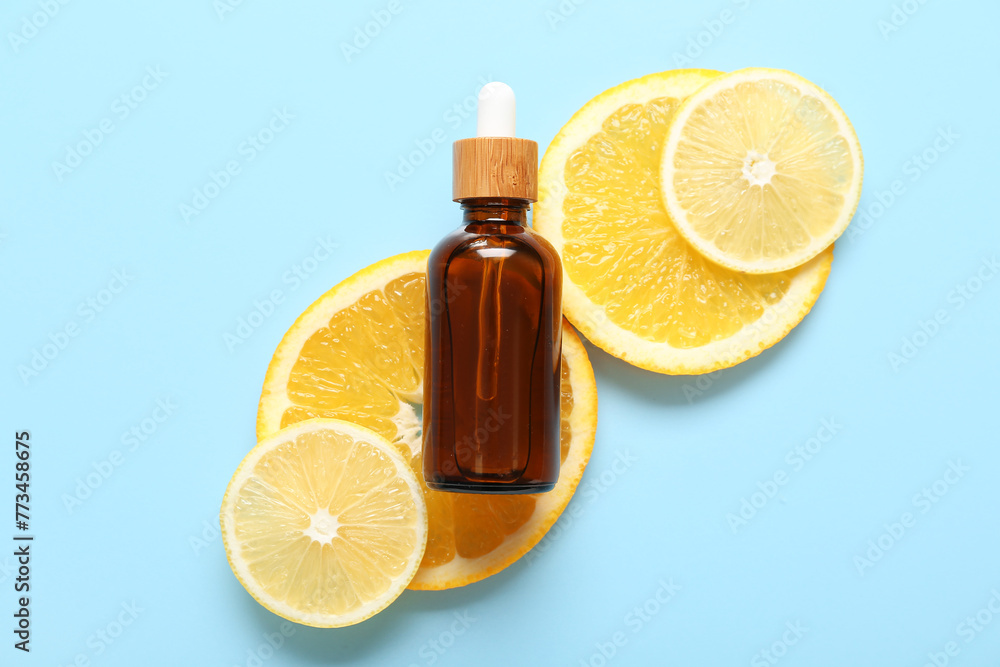 Bottle of vitamin C with citrus fruits slices on blue background Bottle of vitamin C with citrus fruits slices on blue background