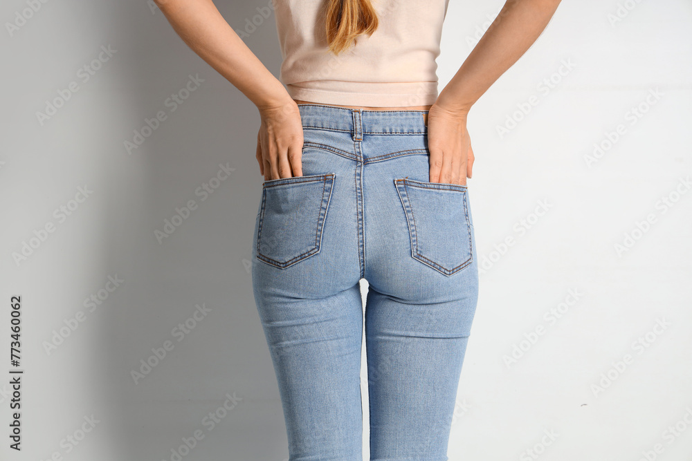 Young woman in stylish jeans pants on white background, back view - obrazy, fototapety, plakaty 