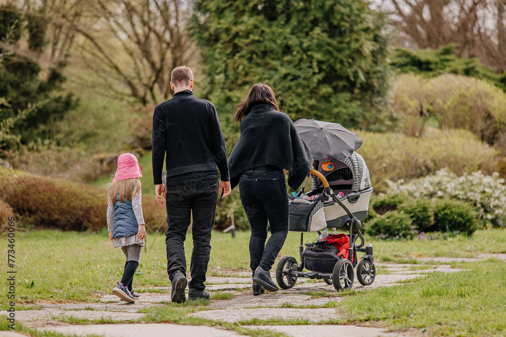 Rodzina z dzieckiem na spacerze w parku - obrazy, fototapety, plakaty 
