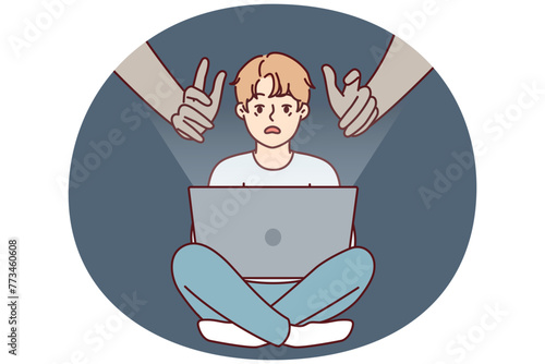 Giant hands reaching out to teenage boy using laptop with internet without parental control. concept of danger of using gadgets by children due to possibility of identity theft © drawlab19