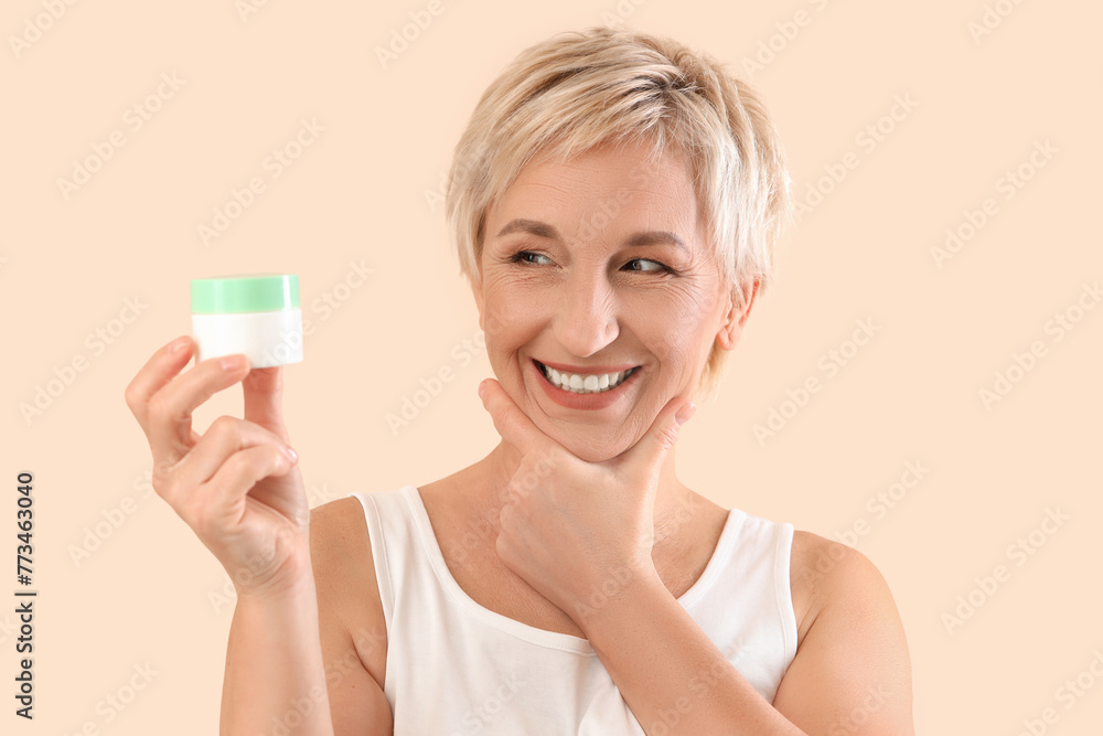 Mature woman with jar of cream on beige background, closeup Mature woman with jar of cream on beige background, closeup