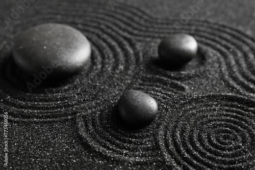 Photography Spa stones on black sand with lines, closeup. Zen concept