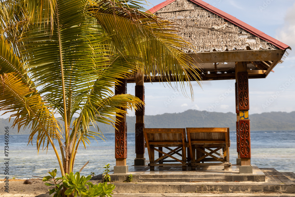 Beautiful gazebo with lounge chairs against the backdrop of the ocean in a Papuan village, West Papua, Indonesia Beautiful gazebo with lounge chairs against the backdrop of the ocean in a Papuan village, West Papua, Indonesia
