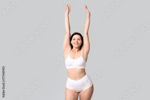 Body positive woman in underwear on light background