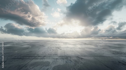An empty concrete floor with a cloudy sky in the background. Suitable for various industrial or outdoor themed projects