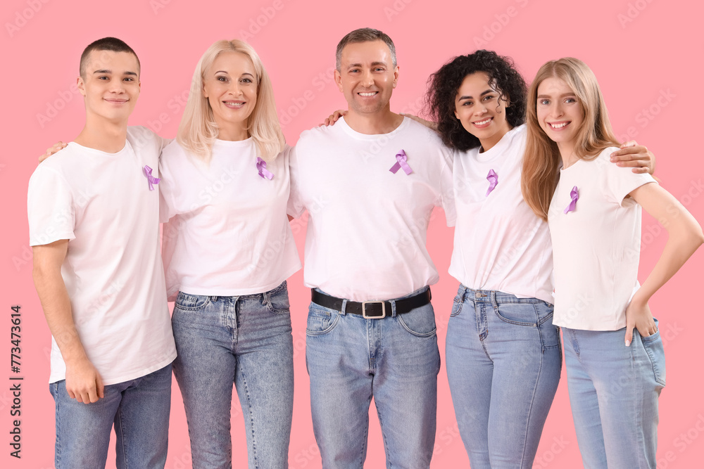 People with lavender awareness ribbons hugging on pink background. World Cancer Day People with lavender awareness ribbons hugging on pink background. World Cancer Day