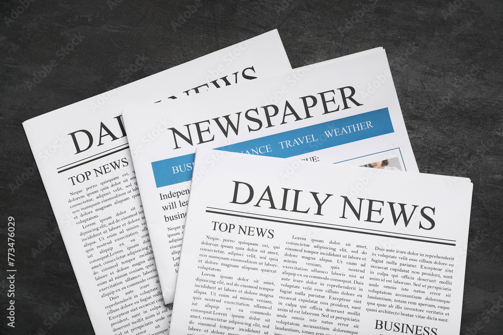 Obraz premium Newspapers on black grunge background