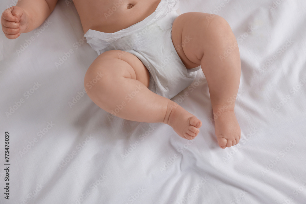 Little baby in diaper lying on bed, top view Little baby in diaper lying on bed, top view