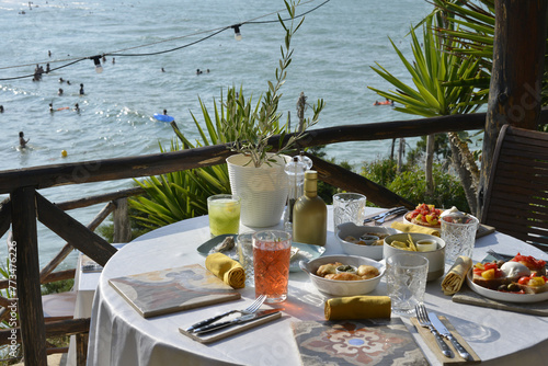 cocktail servito con un abbondante aperitivo servito in un bar in riva al mare