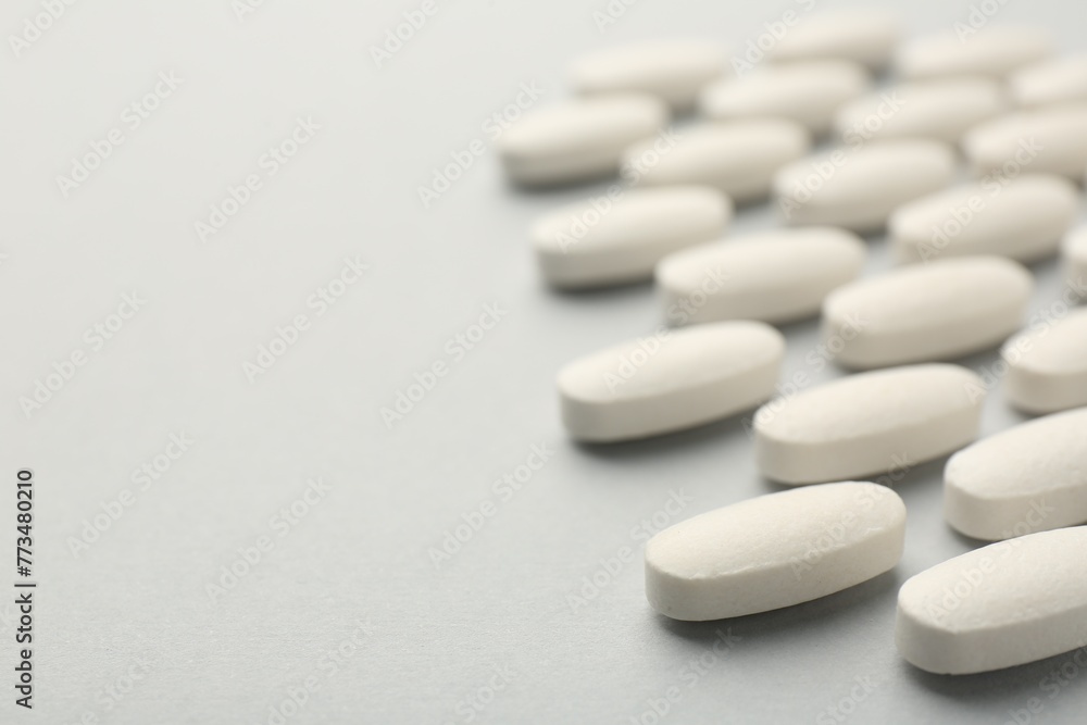 Vitamin pills on light grey background, closeup with pace for text. Health supplement Vitamin pills on light grey background, closeup with pace for text. Health supplement