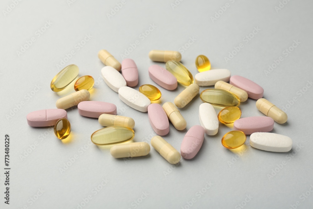Different vitamin pills on light grey background. Health supplement Different vitamin pills on light grey background. Health supplement