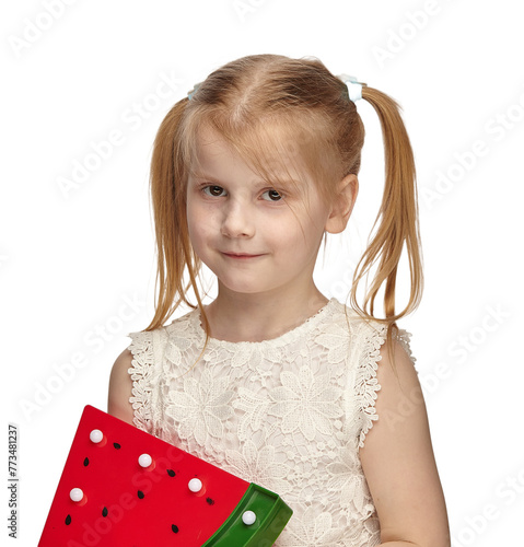 Blonde baby 6 years old, in a white dress shows watermelon