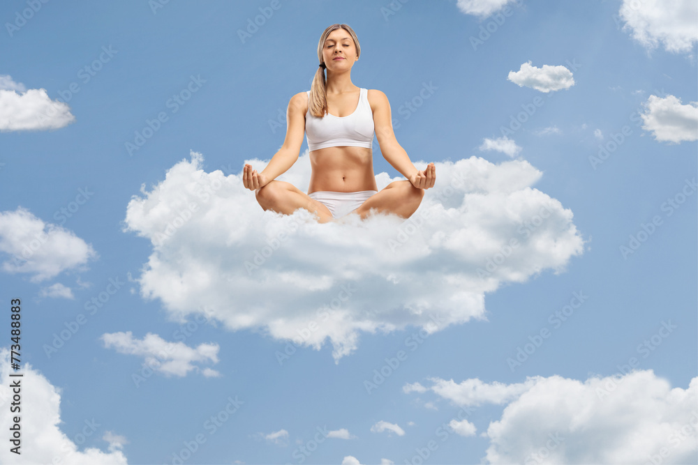 Young woman meditating on clouds up in the sky Young woman meditating on clouds up in the sky