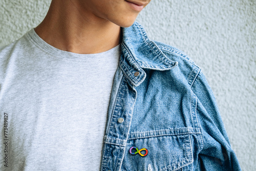 Billede på lærred Teenage boy with autism infinity rainbow symbol sign metallic pin brooch on denim jacket