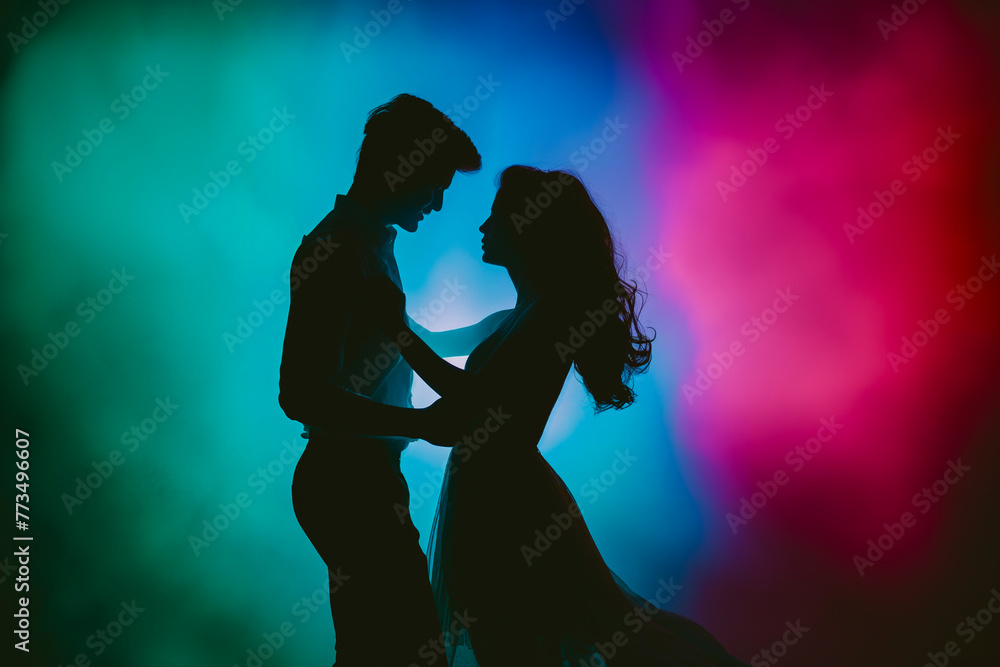 Side view silhouette of young couple dancing against colored dramatic background. Side view silhouette of young couple dancing against colored dramatic background.