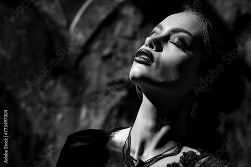 Black and white portrait of a woman with closed eyes, dramatic lighting, and a serene expression, conveying a sense of peace and elegance.