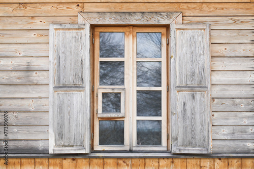 Wooden rustic window in cottage house. Wooden home. Rusty architecture. Podlasie region in Poland vintage wall. Peeling paint decorative exterior shutter. Wood home wall facade. Living in woods.